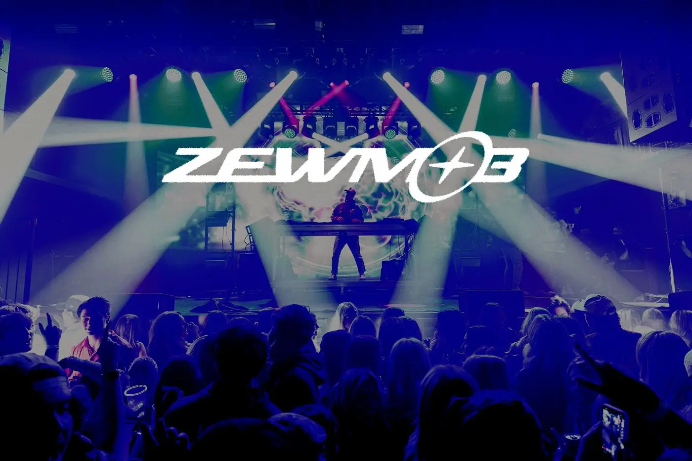 Zewmob performing to a packed crowd under white stage lights