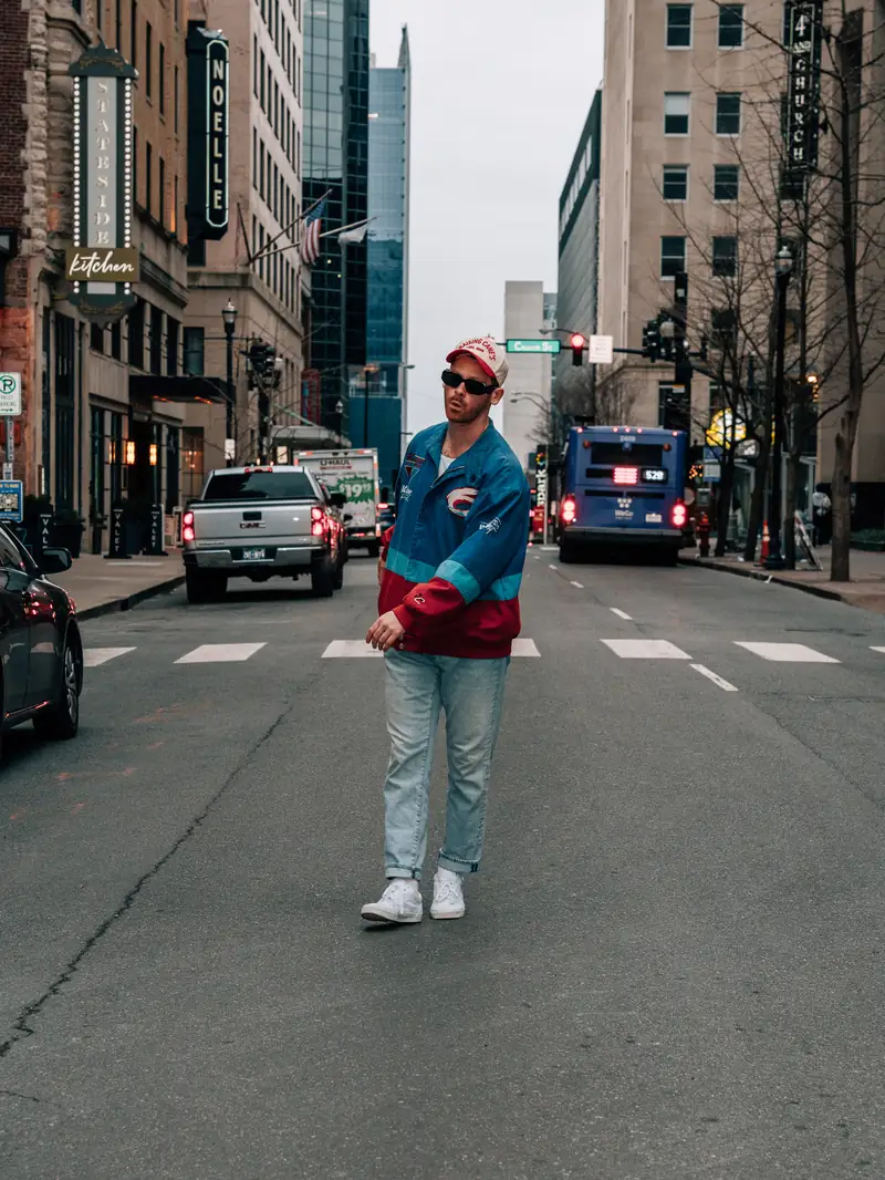 Zewmob walking down the middle of a downtown Nashville street in a racing jacket
